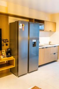 a large stainless steel refrigerator in a kitchen at Loft moderno e aconchegante no coração de Icaraí in Niterói