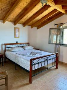 a bed in a bedroom with a wooden ceiling at Samos Panorama Hills in Pythagoreio +16 photos