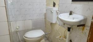 a bathroom with a toilet and a sink at Hotel Shyam in Agra +2 photos