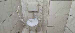 a bathroom with a toilet in a tiled wall at Hotel Shyam in Agra