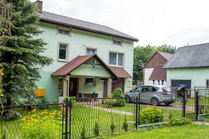 a house with a car parked in front of it at ALE WIDOKI Apartamenty Gościnne in Giebło