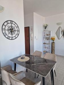 a dining room with a table and a clock on the wall at Compass Apartment in Trogir +26 photos