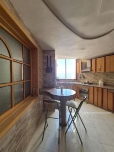 a kitchen with a table and chairs in a room at Apartment Konouz Meknes in Meknès