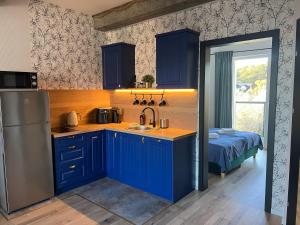 a kitchen with blue cabinets and a sink and a bed at CZARNY BARAN in Dębki