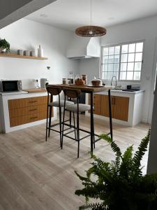 a kitchen with a table and two stools at Coastal Sands Azores in Ribeira Grande