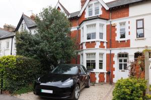 a black car parked in front of a house at Stylish, Spacious, Oxford Townhouse, Driveway parking in Oxford