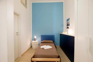 a bedroom with two beds and a blue wall at Pozzallo yellow house,5'dal mare in Pozzallo