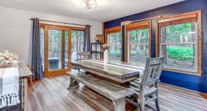 a dining room with a wooden table with a bench at Pine Loch, sleeps 9, 3 bedroom, 2 bath, gas fire pit on deck in Pocono Lake