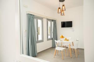 a white dining room with a table and chairs at Galaxy studios in Astypalaia