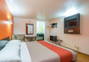 a hotel room with a bed and a flat screen tv at Motel 6-Round Rock, TX in Round Rock