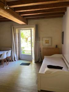 a bedroom with a bed and a sliding glass door at L'Aveneau - Havre champêtre avec piscine d'été in Le Retail