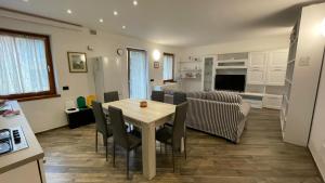 a kitchen and living room with a table and chairs at Appartamenti Bion in Levico Terme