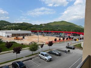 a parking lot with cars parked in front of a building at Apartman I&I in Kiseljak