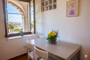 a table with a vase of flowers on it with a window at The River House in Bagnone
