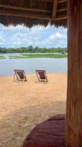 two chairs sitting on a beach near the water at Hôtel Lucia Grand Lahou in Grand-Lahou +13 photos