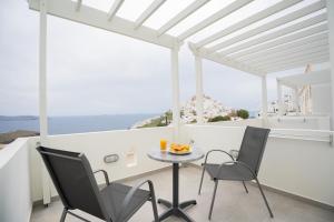 a table and chairs on a balcony with a view of the ocean at Galaxy studios in Astypalaia