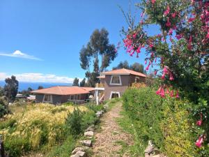 a house on the side of a hill with flowers at Musiña Lodge in Ocosuyo