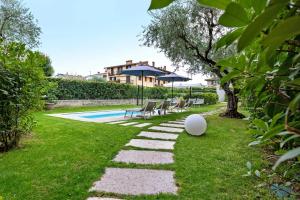 a backyard with a swimming pool and a lawn at Le Logge del Garda in San Felice del Benaco