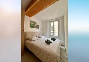 a bedroom with a bed with two shoes on it at L'olivier du vieil Antibes in Antibes