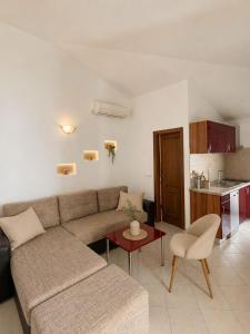 a living room with a couch and a table and a kitchen at Apartmani Kuic in Milna