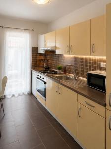 a kitchen with white cabinets and a sink at Apartmani Kuic in Milna +5 photos