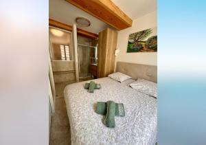 a bedroom with a bed with green towels on it at L'olivier du vieil Antibes in Antibes