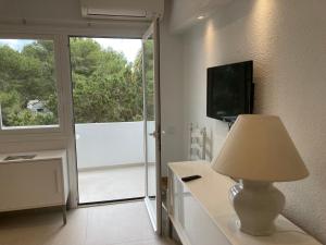 a living room with a lamp and a sliding glass door at Costamar 15 - Pool - 3 minutes to the beach in Es Pujols