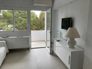 a bedroom with a bed and a lamp and a window at Costamar 15 - Pool - 3 minutes to the beach in Es Pujols