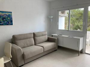 a living room with a couch and a window at Costamar 15 - Pool - 3 minutes to the beach in Es Pujols +37 photos