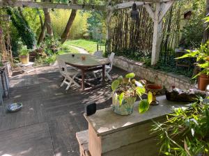 a patio with a table and chairs under a pergola at Chambre chez l'habitant dans grande maison Arborée in Orly