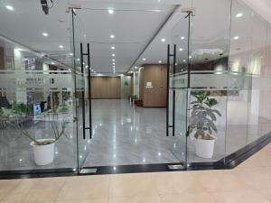 a glass corridor with potted plants in a building at Bunker in Baguio