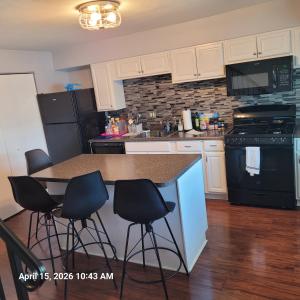 a kitchen with white cabinets and a counter with bar stools at The Haven in Dundalk
