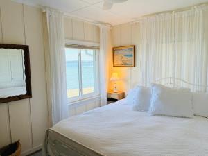 a bedroom with a bed with a view of the ocean at Ma Margarets House Bed and Breakfast in Reedville