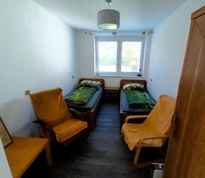 a room with two beds and a chair and a window at Chalupa U Vinaře in Radějov +55 photos
