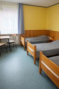 a room with two beds and a table and chairs at Wildes Amrum Island Basecamp Backpacker & Nature Stay in Norddorf