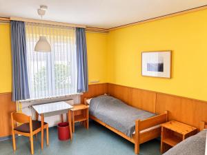 a small room with a bed and a table at Wildes Amrum Island Basecamp Backpacker & Nature Stay in Norddorf