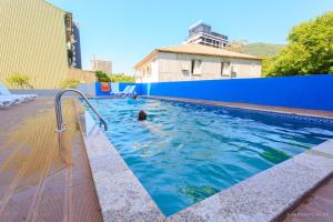 a person swimming in a swimming pool at Scorpio Hotel Gonio in Gonio