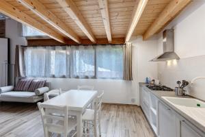 a kitchen with white cabinets and a table and chairs at Le Logge del Garda in San Felice del Benaco