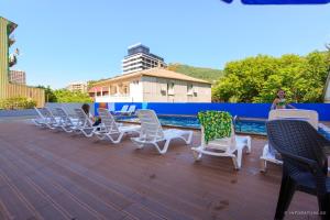 a group of chairs sitting on a deck next to a pool at Scorpio Hotel Gonio in Gonio
