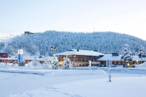 un edificio cubierto de nieve frente a una montaña en Levi Hotel Spa en Levi