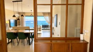 a dining room and kitchen with a table and green chairs at Seafront Luxury Apartment in Kalamata