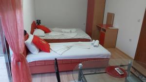 two beds in a room with a glass table at Apartmani Moco in Ulcinj
