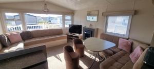 a living room with a couch and a table at E21 The Sandy Heaven in Lossiemouth