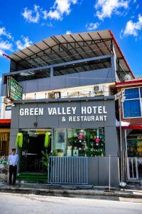 a man standing in front of a green valley hotel and restaurant at Green Valley Hotel - Srinagar in Srīnagar
