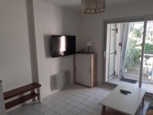 a living room with a tv on the wall at Pointe Saint-Jacques - L'entre deux vagues in Sarzeau