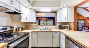 a kitchen with white cabinets and a sink at Pine Loch, sleeps 9, 3 bedroom, 2 bath, gas fire pit on deck in Pocono Lake