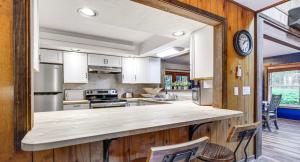 a kitchen with white cabinets and a large counter top at Pine Loch, sleeps 9, 3 bedroom, 2 bath, gas fire pit on deck in Pocono Lake