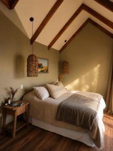a bedroom with a large bed and a table at Boutique Cabin with Strait of Magellan Views in Punta Arenas +8 photos