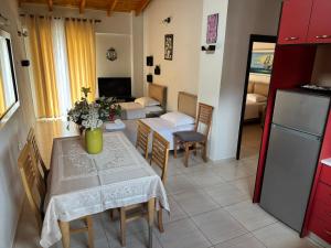 a kitchen and a living room with a table and chairs at George Hotel Rooms&Suites in Himare