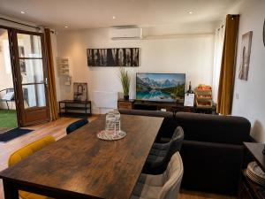 a living room with a wooden table and a couch at Entre parenthèses - Grand confort et Parking privé in Le Fousseret +6 photos